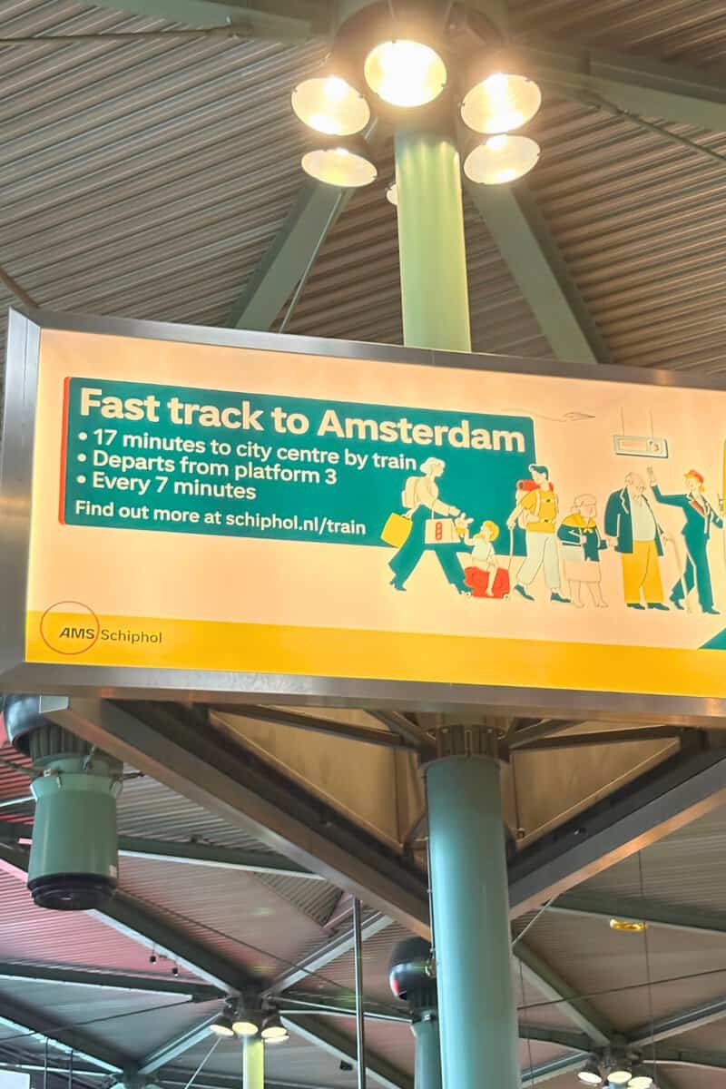 Schiphol Airport sign showing trains to Amsterdam city centre in 17 minutes from platform 3, every 7 minutes.