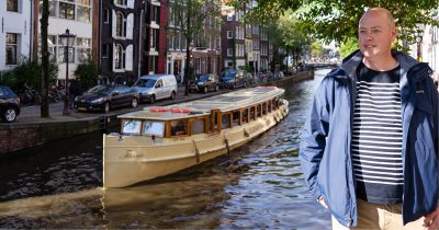 Gerrit in front of small canal boat tour Amsterdam. In a Netherlands Trip Planning Call Can I help you with a more local experience.
