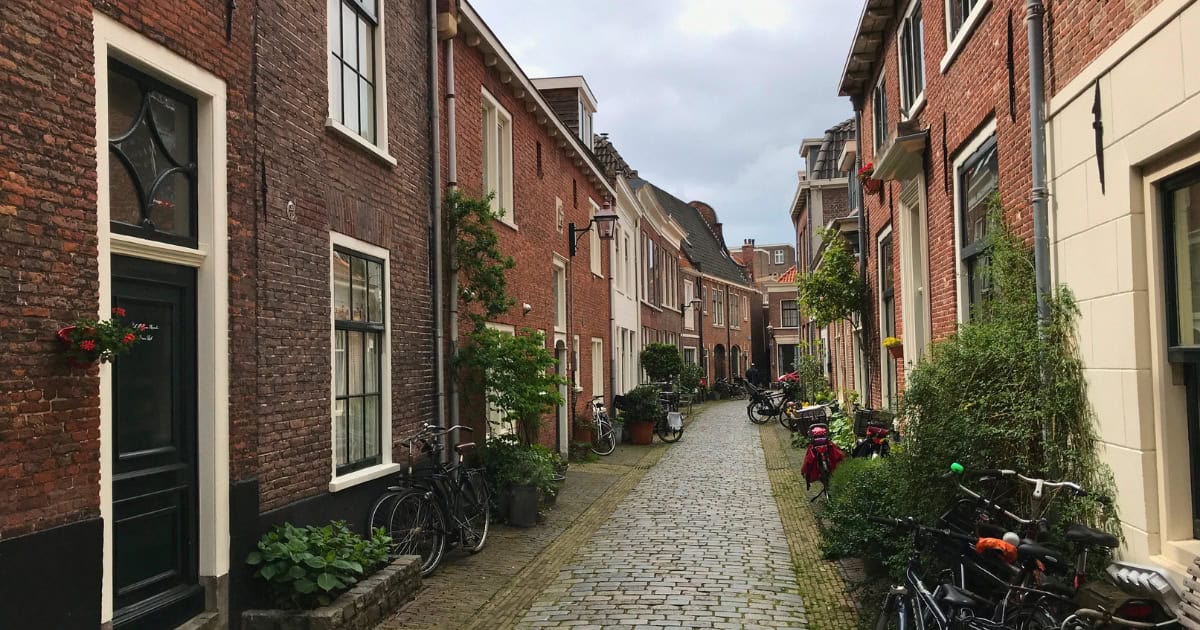 Quiet cobbled residential street with brick houses and bikes in Haarlem, 15 minutes by train from Amsterdam.
