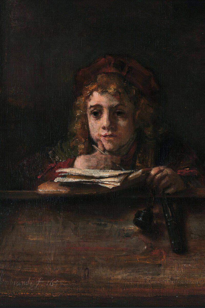 Painting by Rembrandt of his son Titus, around fourteen, sitting daydreaming at a worn wooden writing desk with a pen in his hand and an inkwell hanging at his side, curly blond hair under a soft cap, in warm brown and reddish tones.
